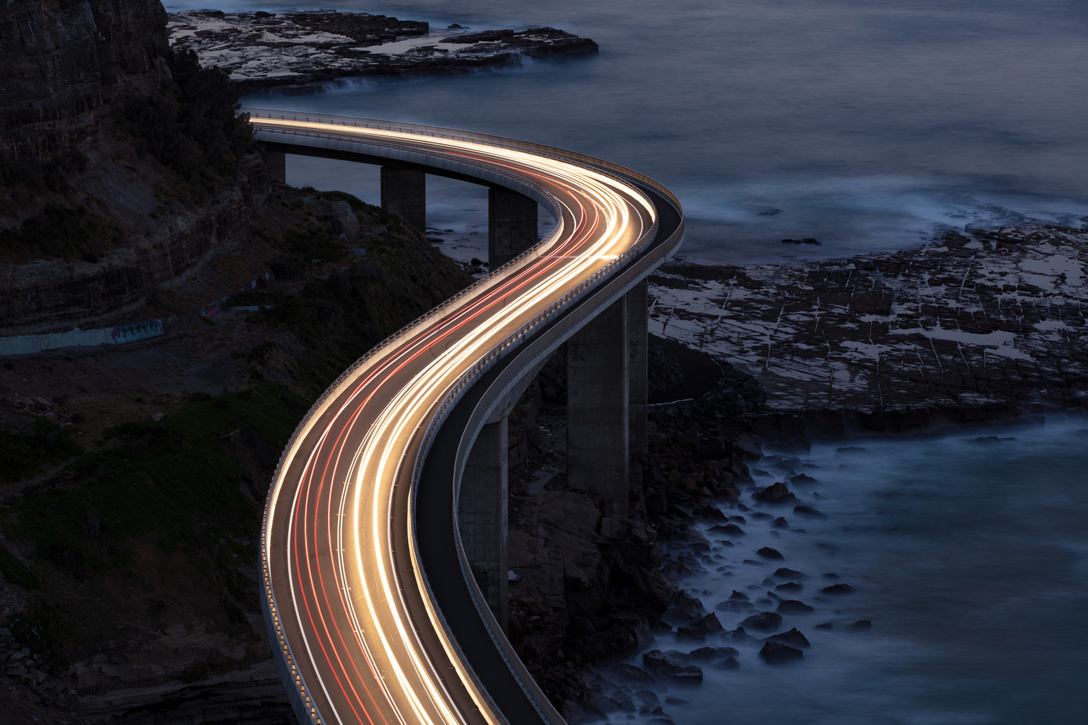 Car light trails on Sea Cliff Bridge, a balanced cantilever bridge located south of Sydney, New South Wales, Australia