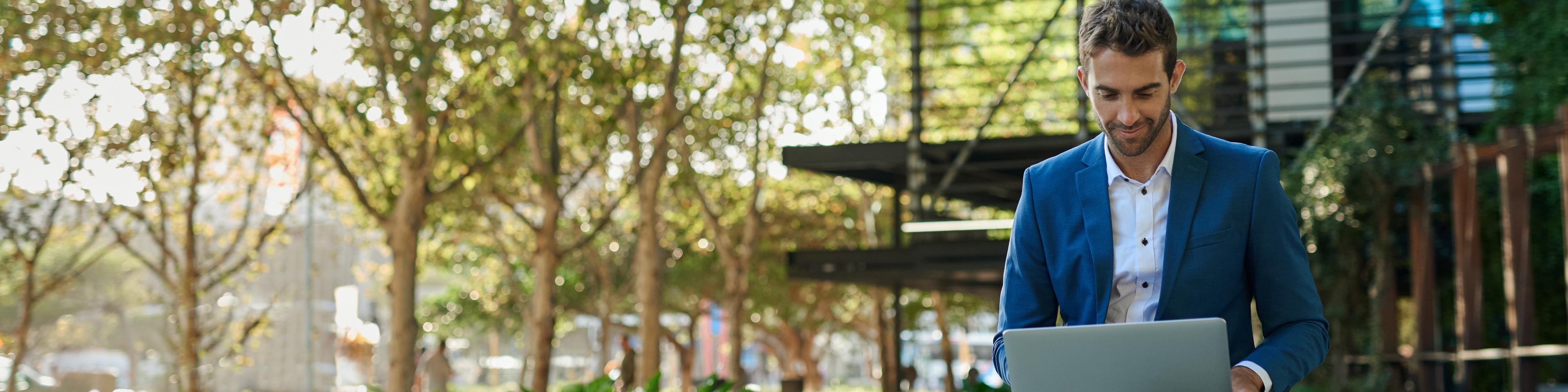 Businessman outside looking at laptop