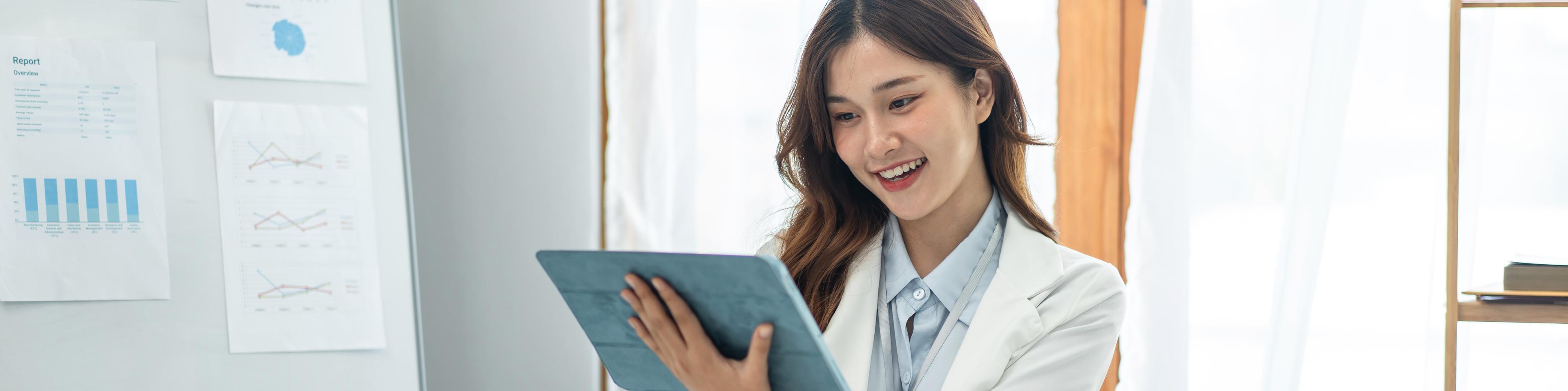 Woman looking at tablet and making notes