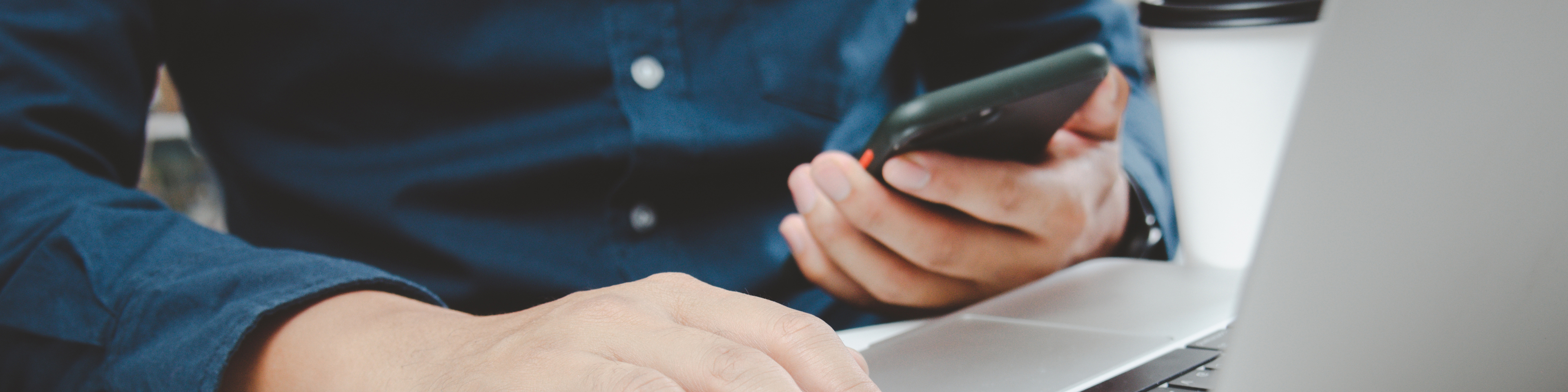 Man uses mobile phone and computer