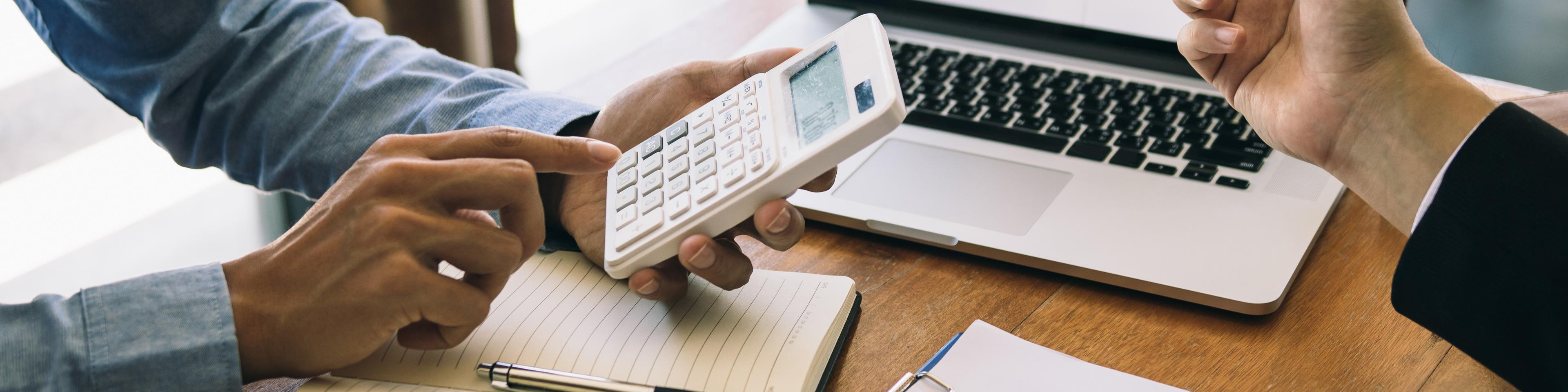 discussing business with calculator and laptop behind