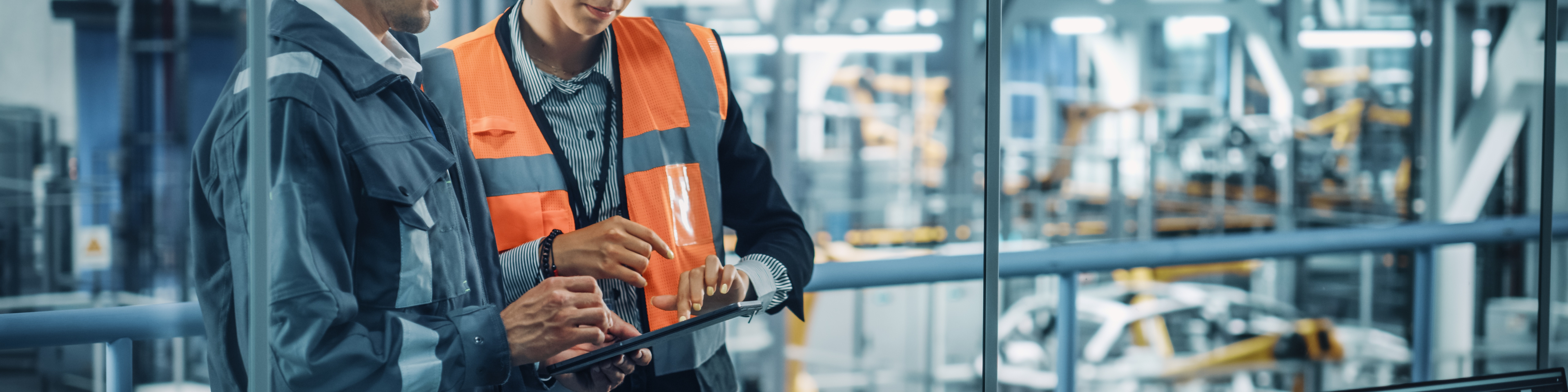 Male Engineer and Female Industrial Product Designer Discuss Work while Using Tablet in Office at a Car Assembly Plant. Industrial Specialists Working on Vehicle Design in Technological Factory.