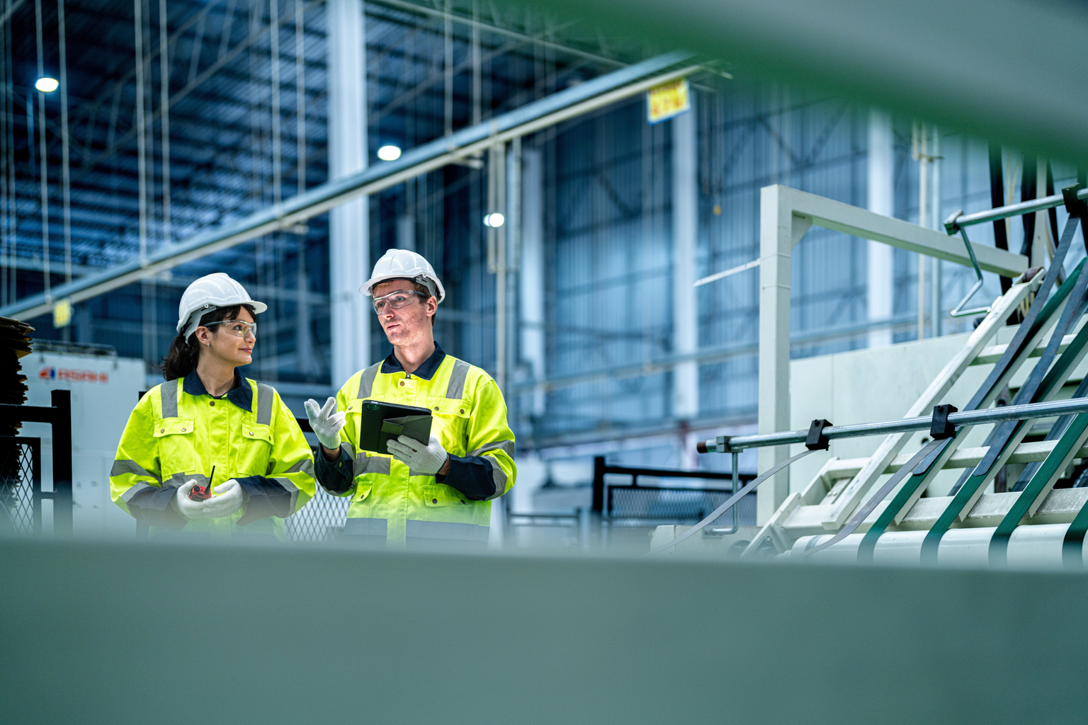 male and female technician engineers checking the process on Heavy machine. mechanical engineering team production. Industry manufacturing. Worker holding tablet and folde. High technology production.