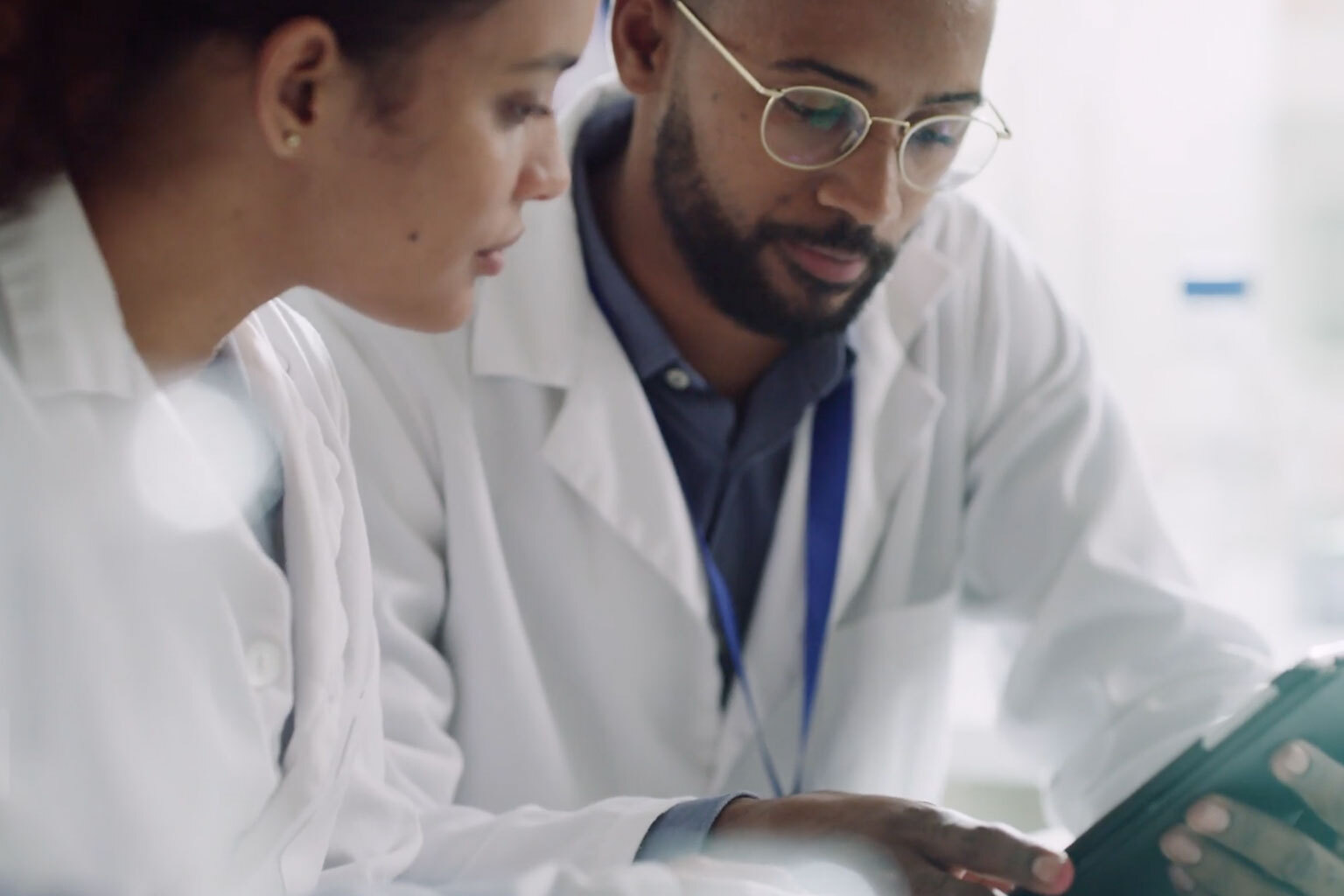 Two doctors looking at UpToDate on mobile device.