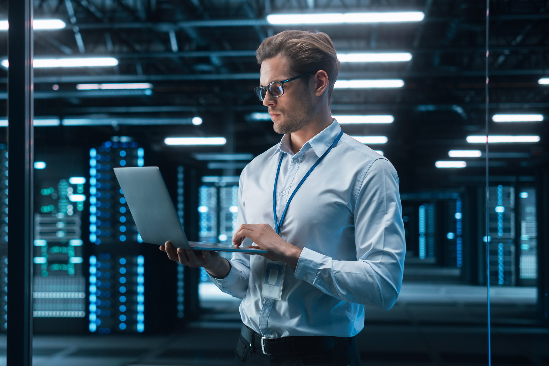 Portrait of IT Specialist Uses Laptop in Data Center