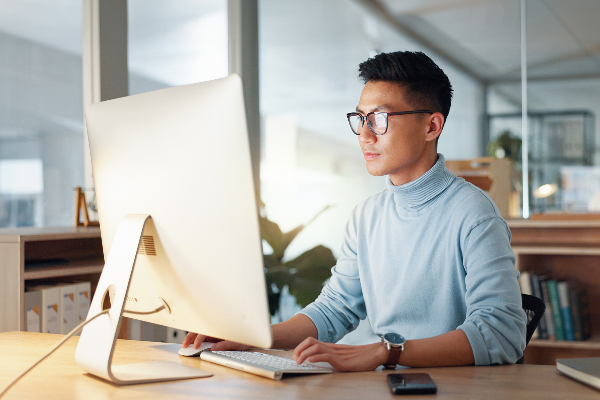 Asian man at computer, glasses and ideas, thinking and reading email, web review or article at digital agency