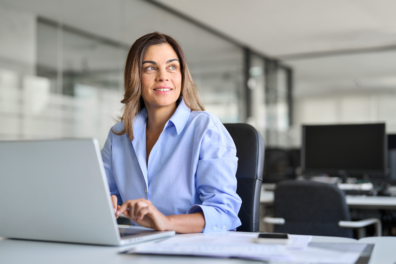 Woman smiling and working on laptop