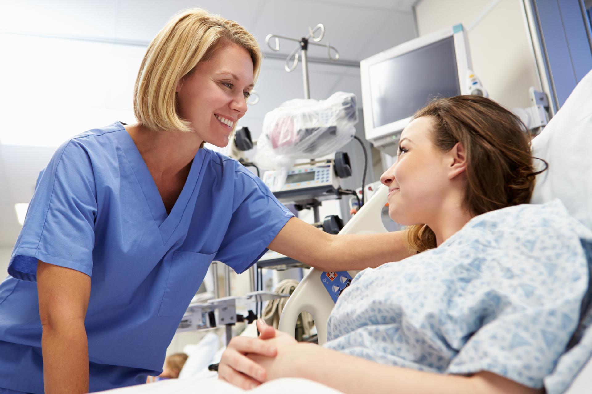 A nurse provides comfort and care at a patient's bedside in the Emergency Medicine department