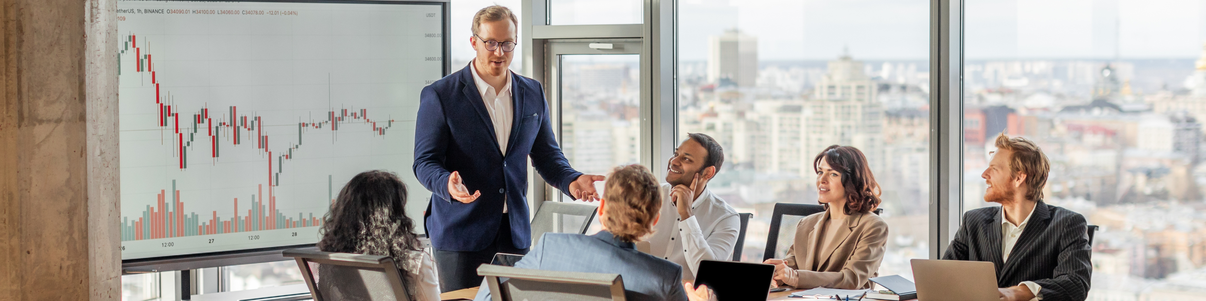 A group of business professionals gathered around a table analyzing a financial chart