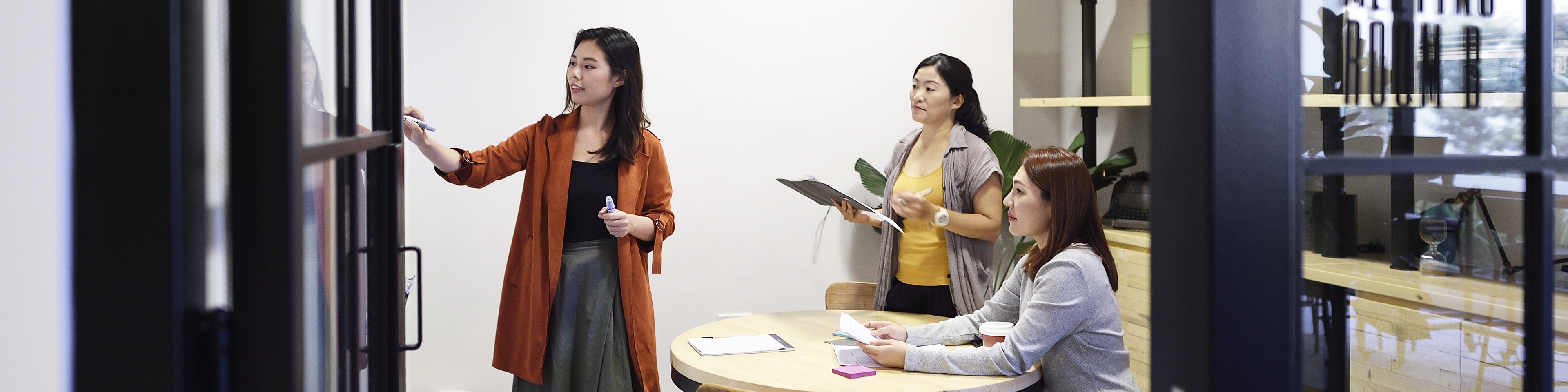 Chinese women brainstorming in an office at night