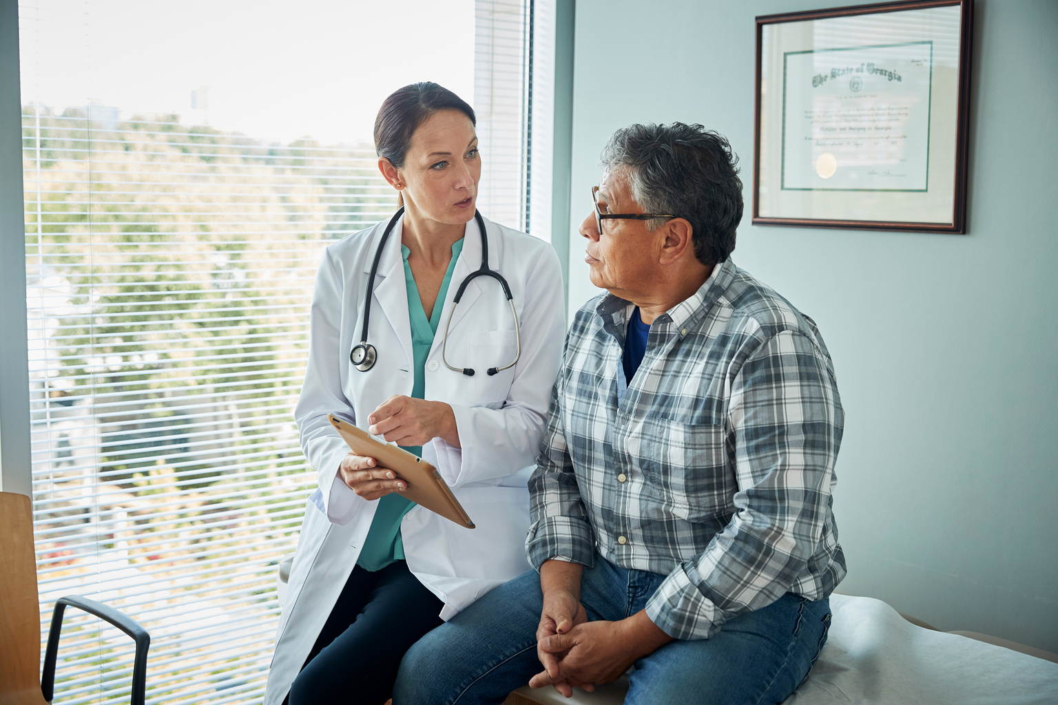 Female doctor providing consultation to middle aged male patient