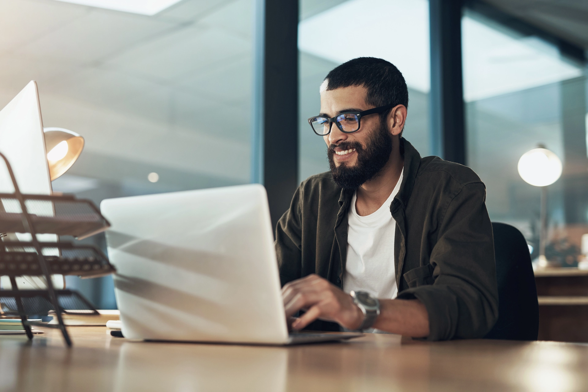 Mann schaut auf Laptop und tippt