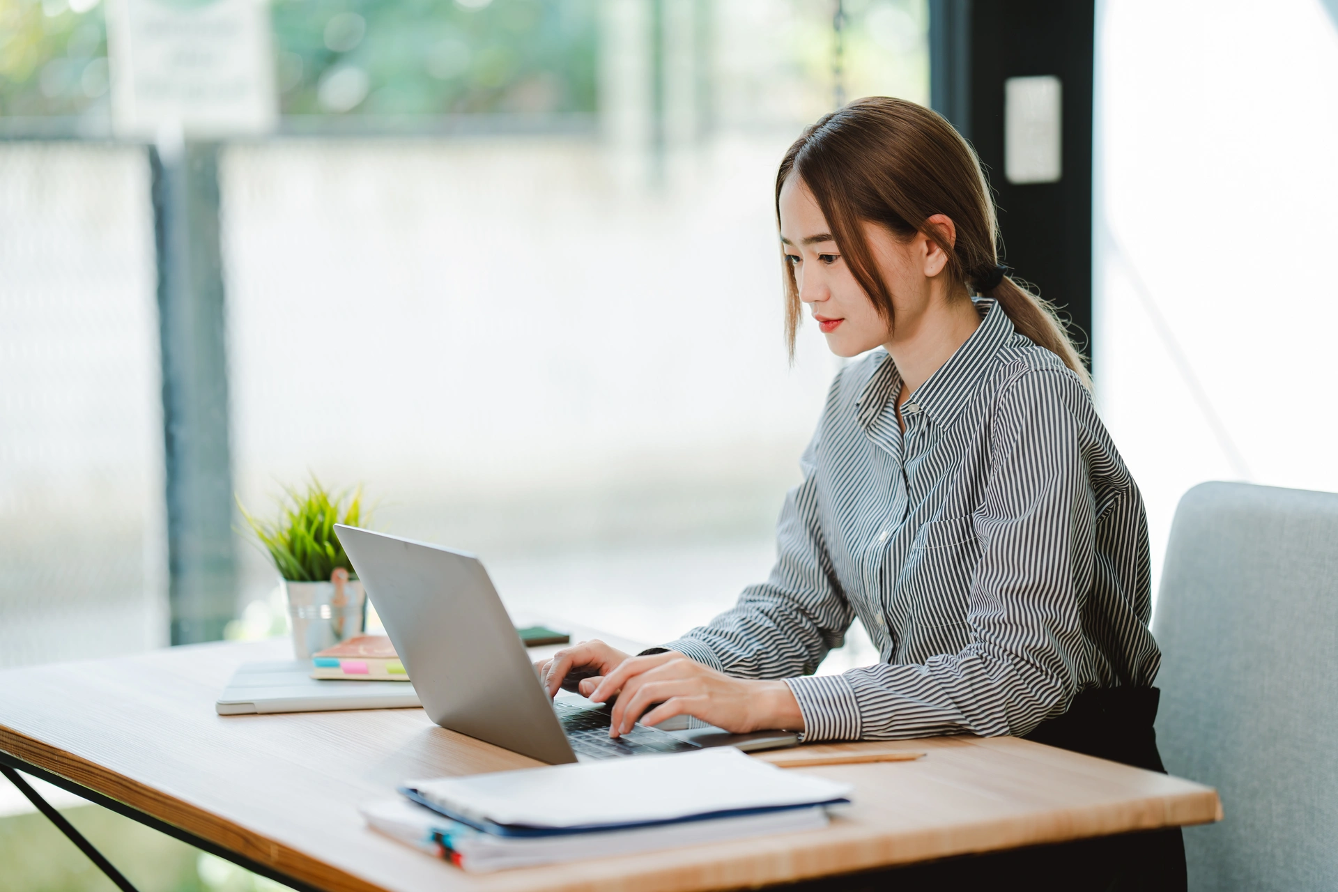 Asian businesswoman working at office using laptop and documents