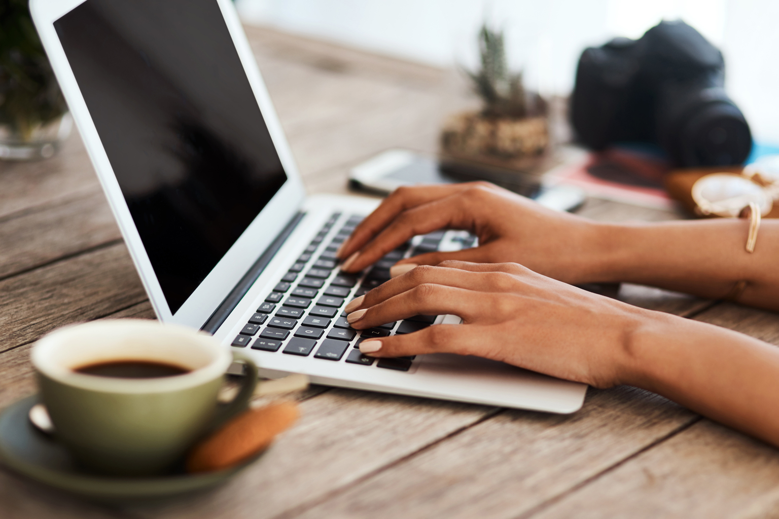 Close up of woman's hands typing on laptop