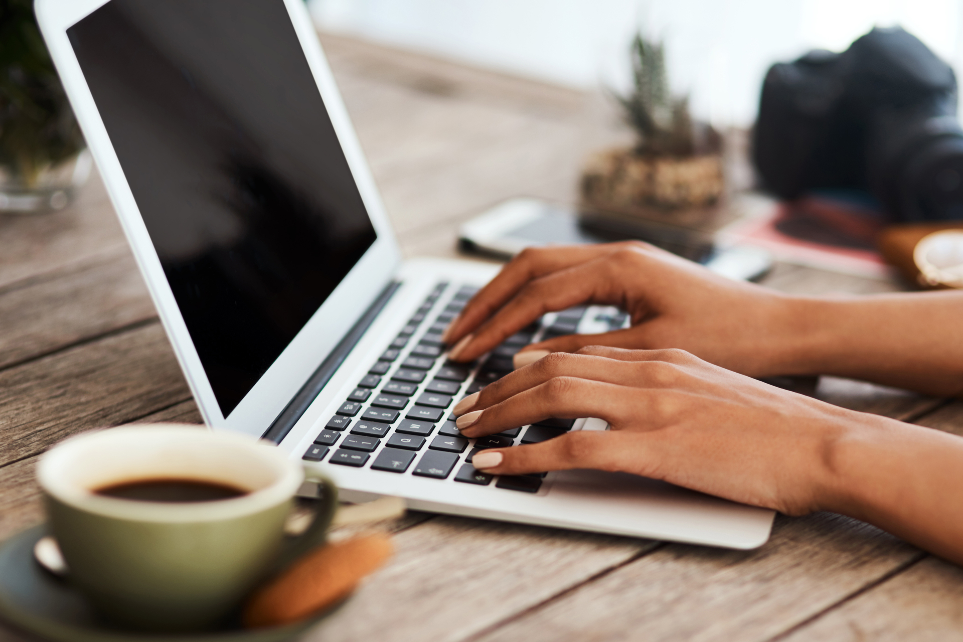 Close up of woman's hands typing on laptop