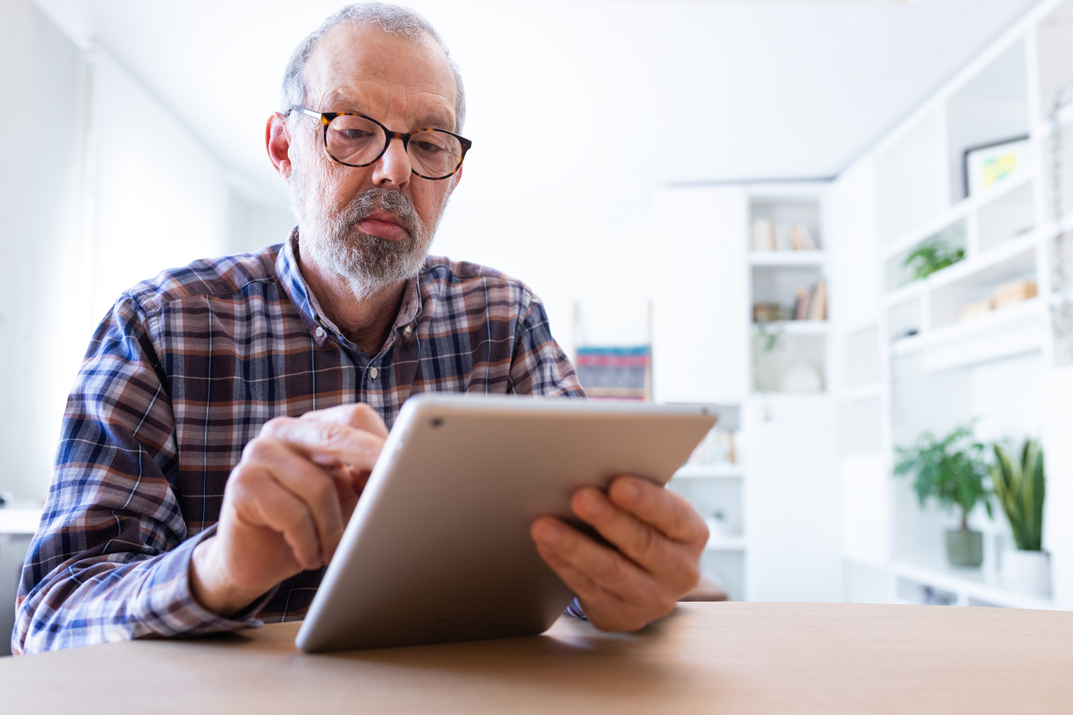 Portrait of a senior man using a tablet at home