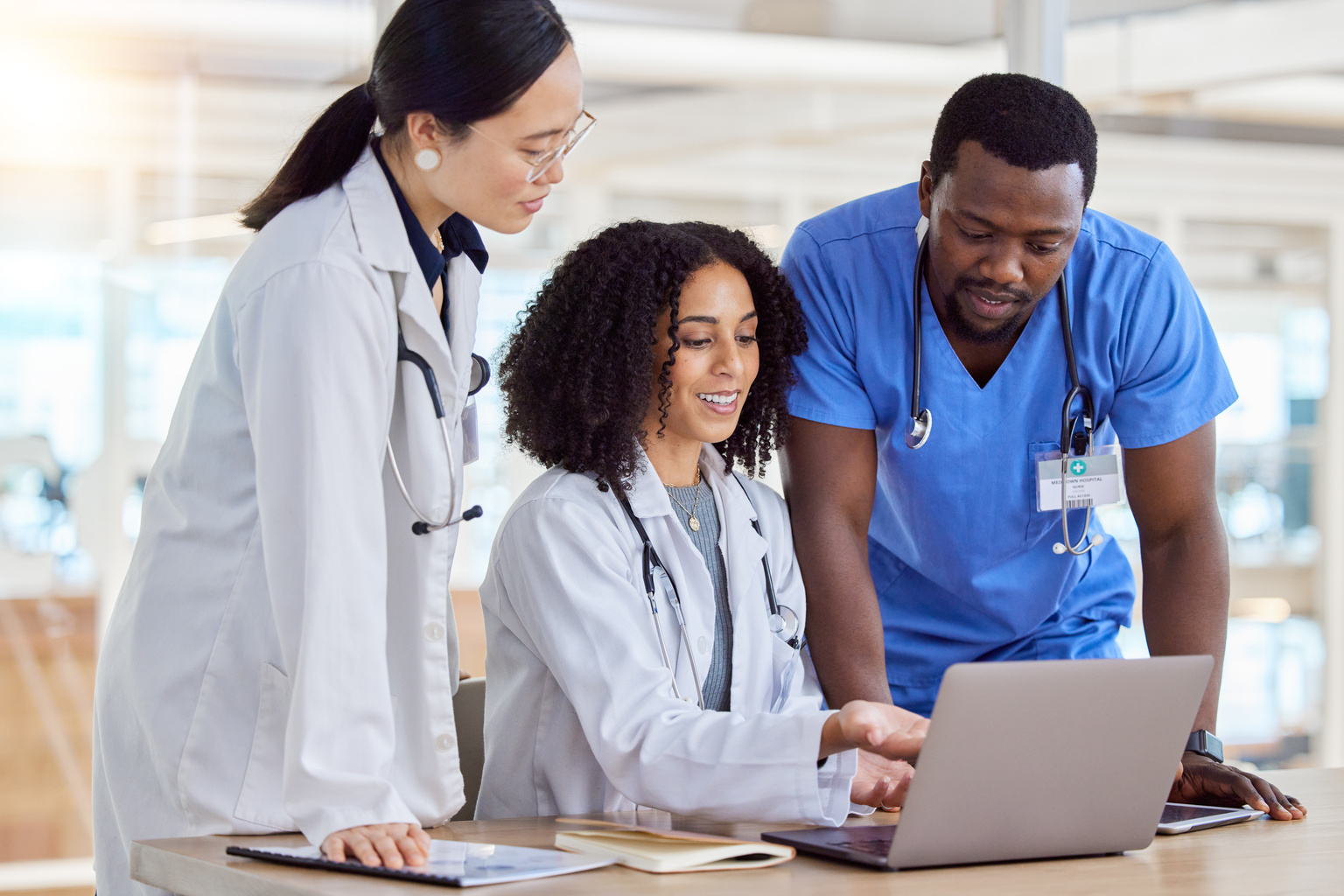 Group collaboration of doctors reading healthcare results on a laptop