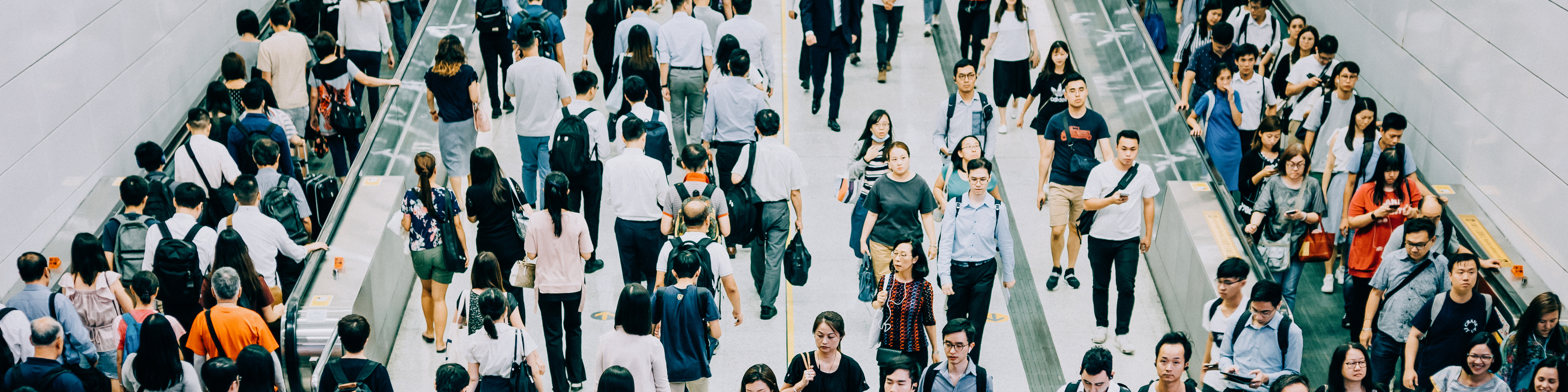 Crowd of busy commuters walking through platforms at subway station during office peak hours in the city