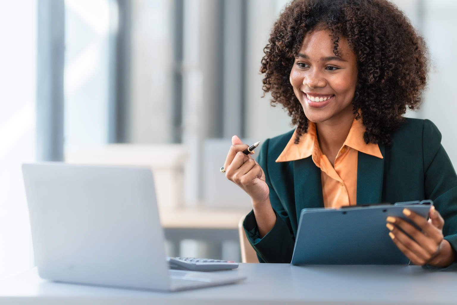 Happy businesswoman looking at her laptop