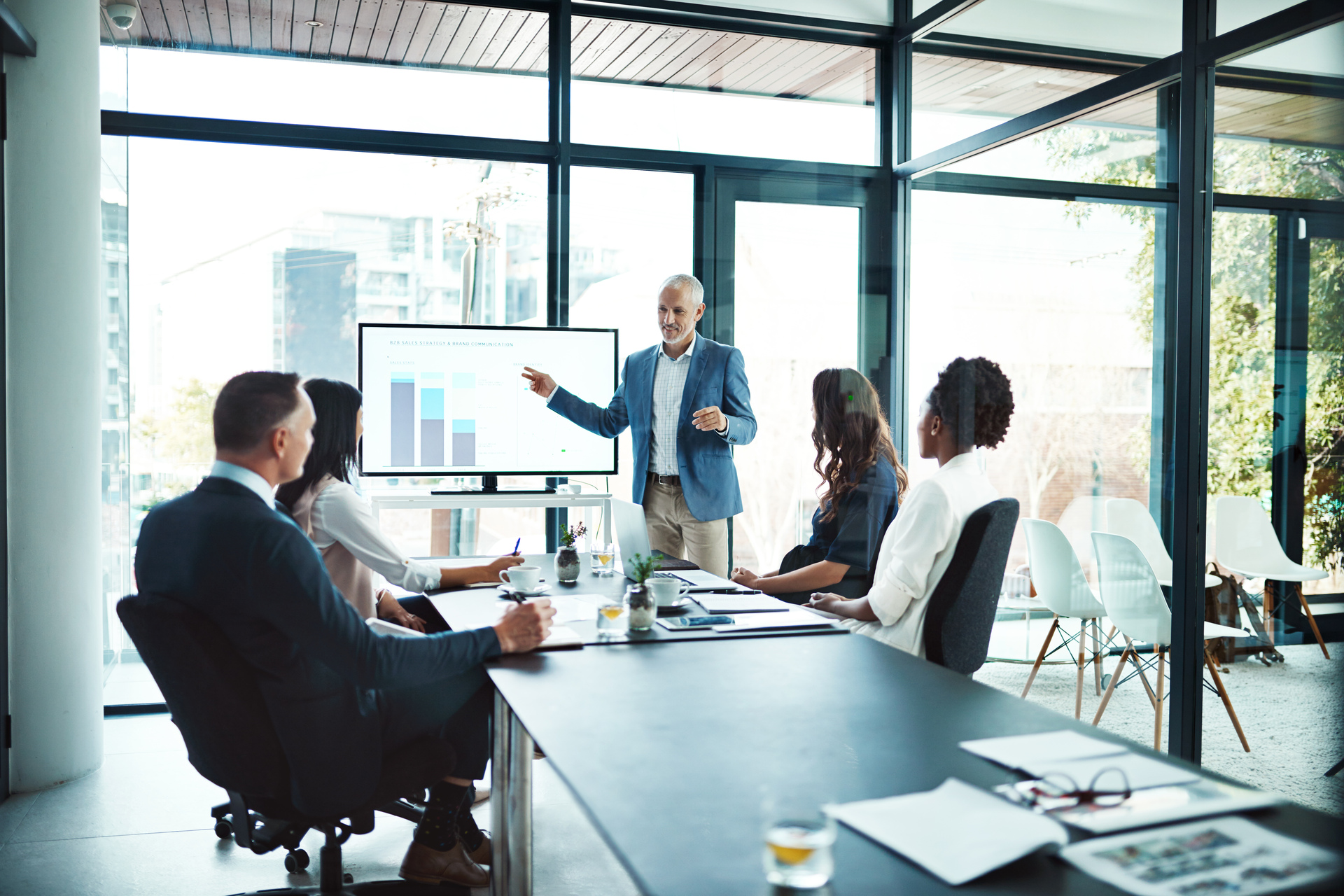 Senior executive with his team discussing data in a conference room. Working as a Team. OneWebGetty2021