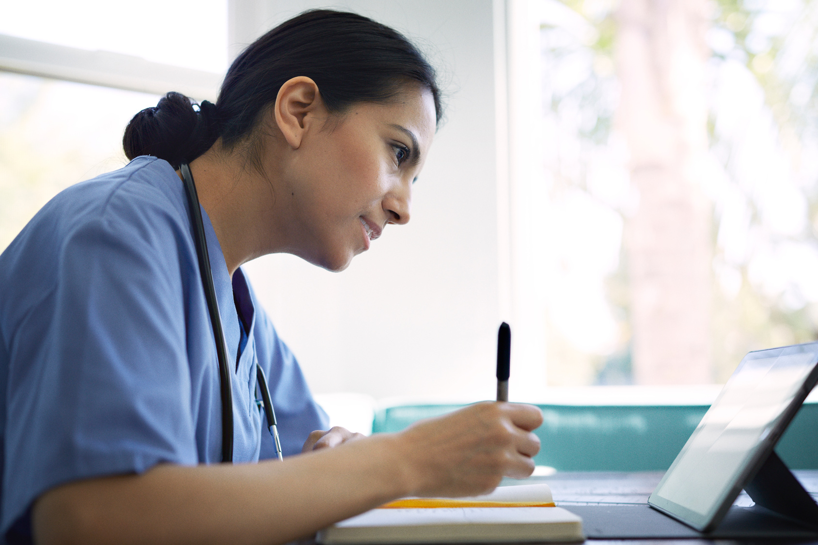 Nurse wearing blue scrubs learning how to create a Clinical Practice Ability framework