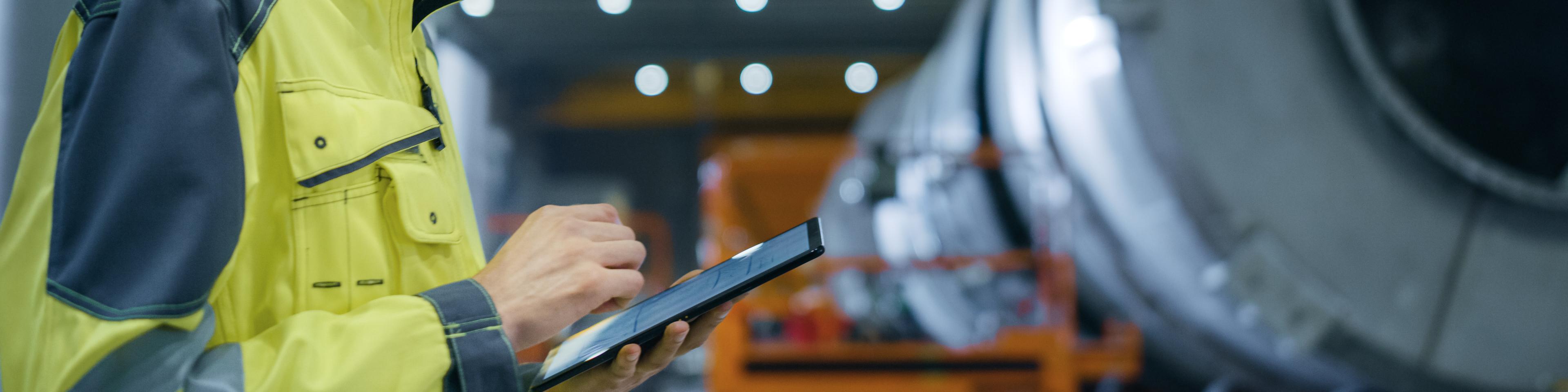 Heavy Industry Engineer in Pipe Manufacturing Factory, Use Digital Tablet Computer. Facility for Construction of Oil, Gas and Fuel Pipeline Transportation Products. Side View