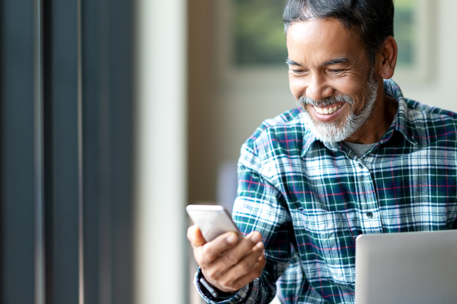 A man holding a smartphone and enjoying an automated tax workflow