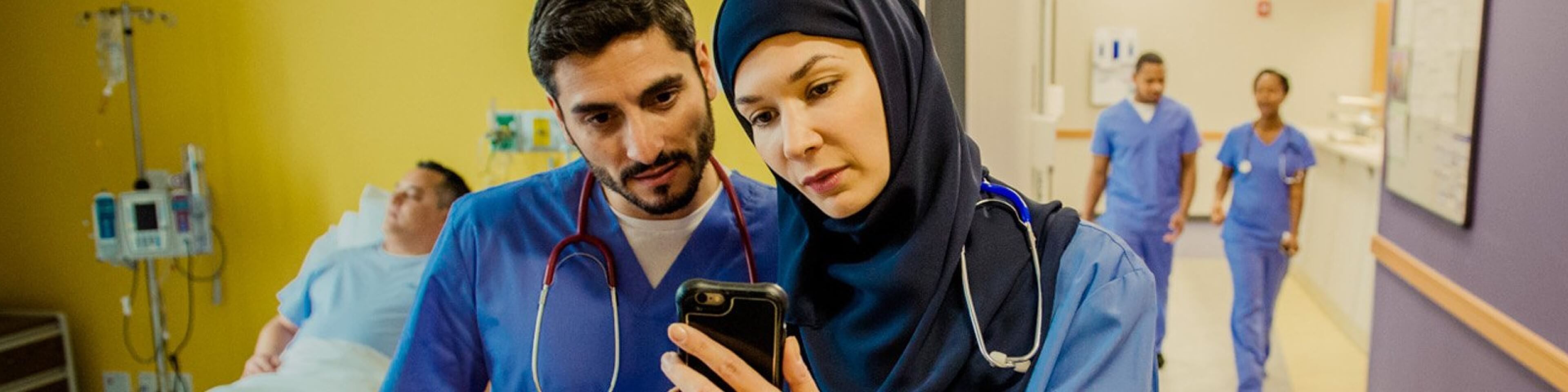 Doctors reviewing patient data on a secure mobile device