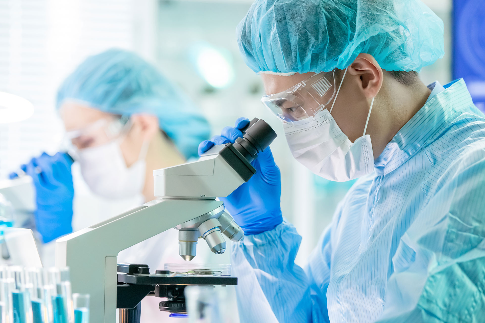 Lab technician conducts cellular research using microscope