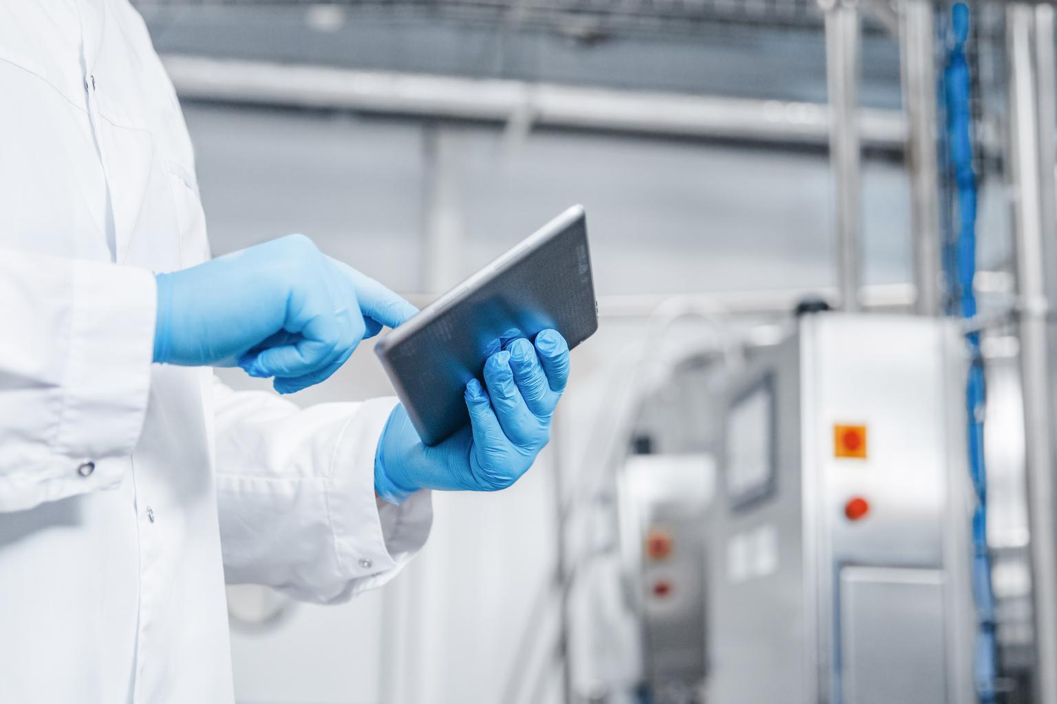 worker holding tablet in factory