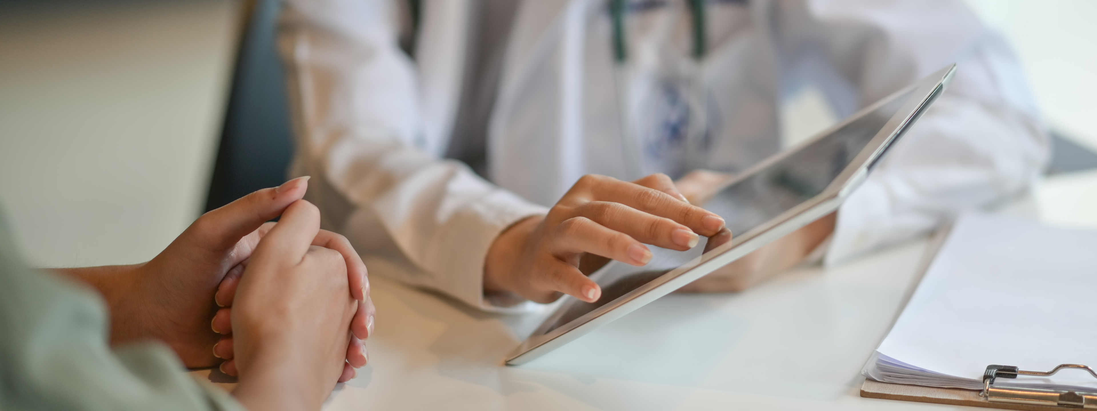 Doctor showing a patient some information on a digital tablet