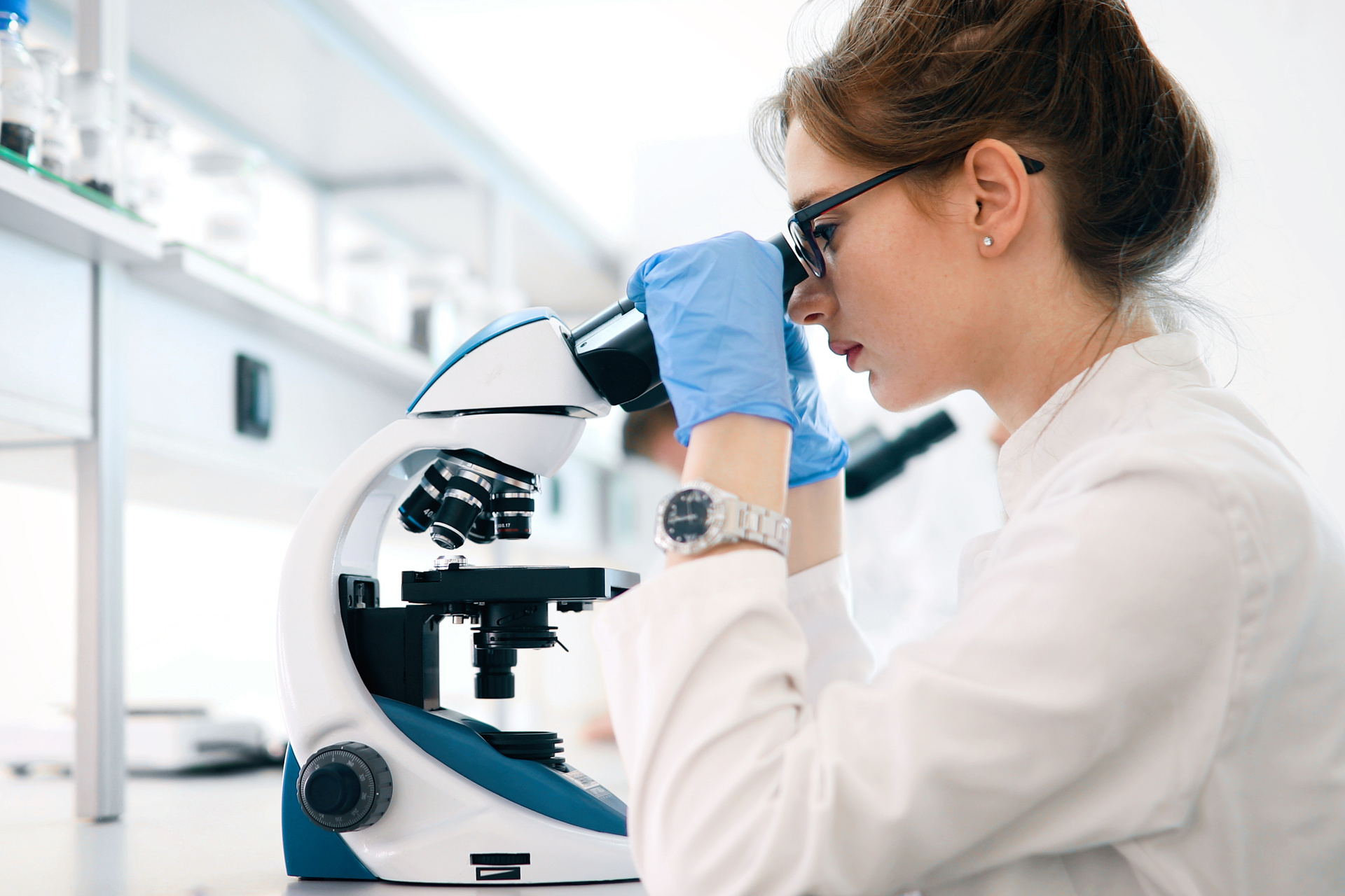 Doctor looking at skin cells under a microscope in a laboratory