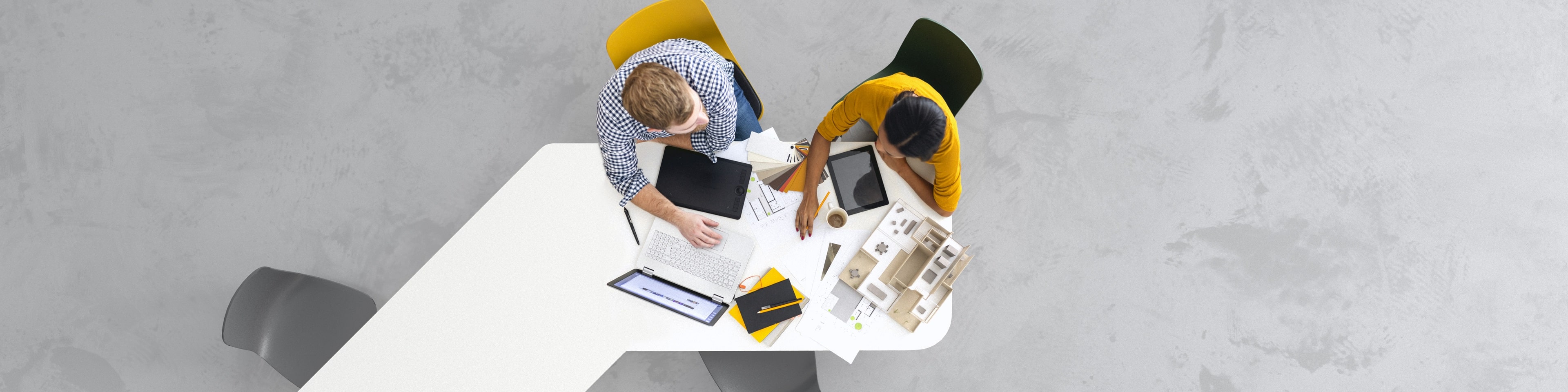 Overhead view of two architects working on a project in the office