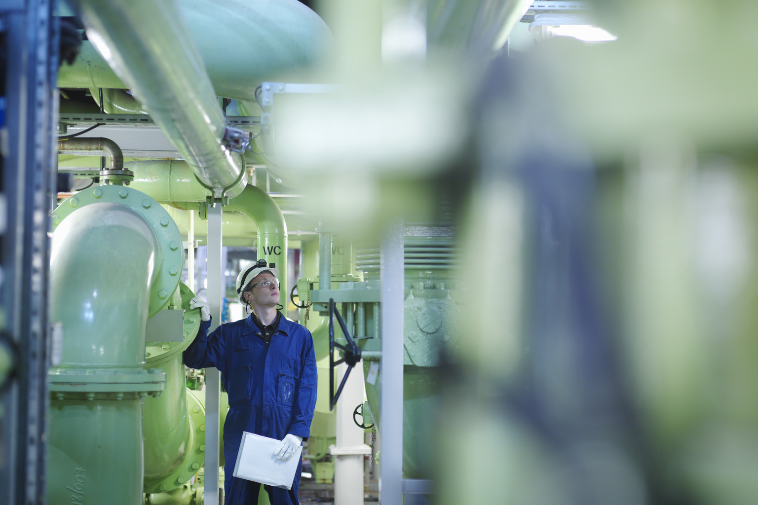 An engineer in hard-hat inspecting fuel and power generation machines