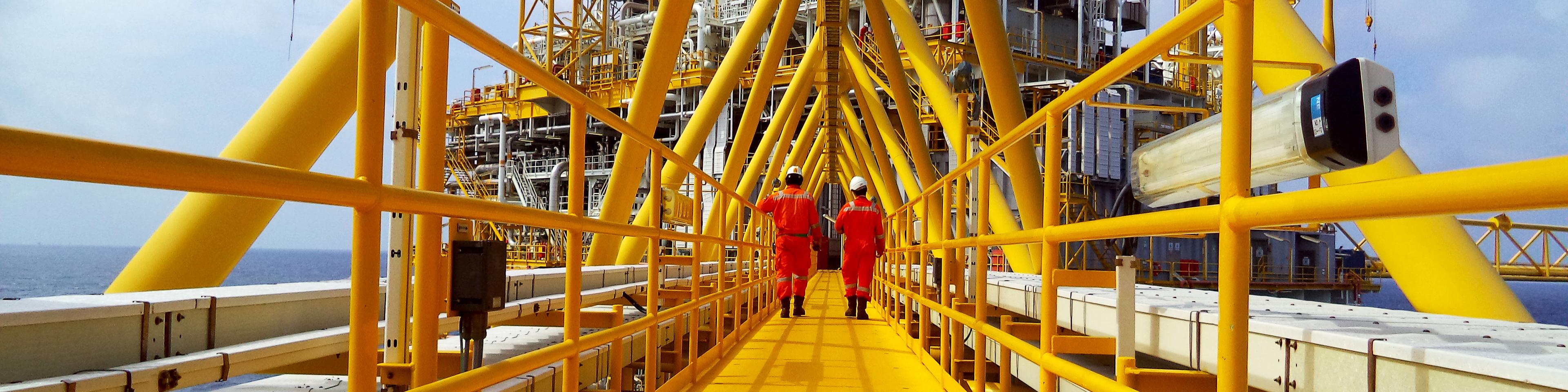 Operator walking operation of oil and gas process at oil and rig plant.