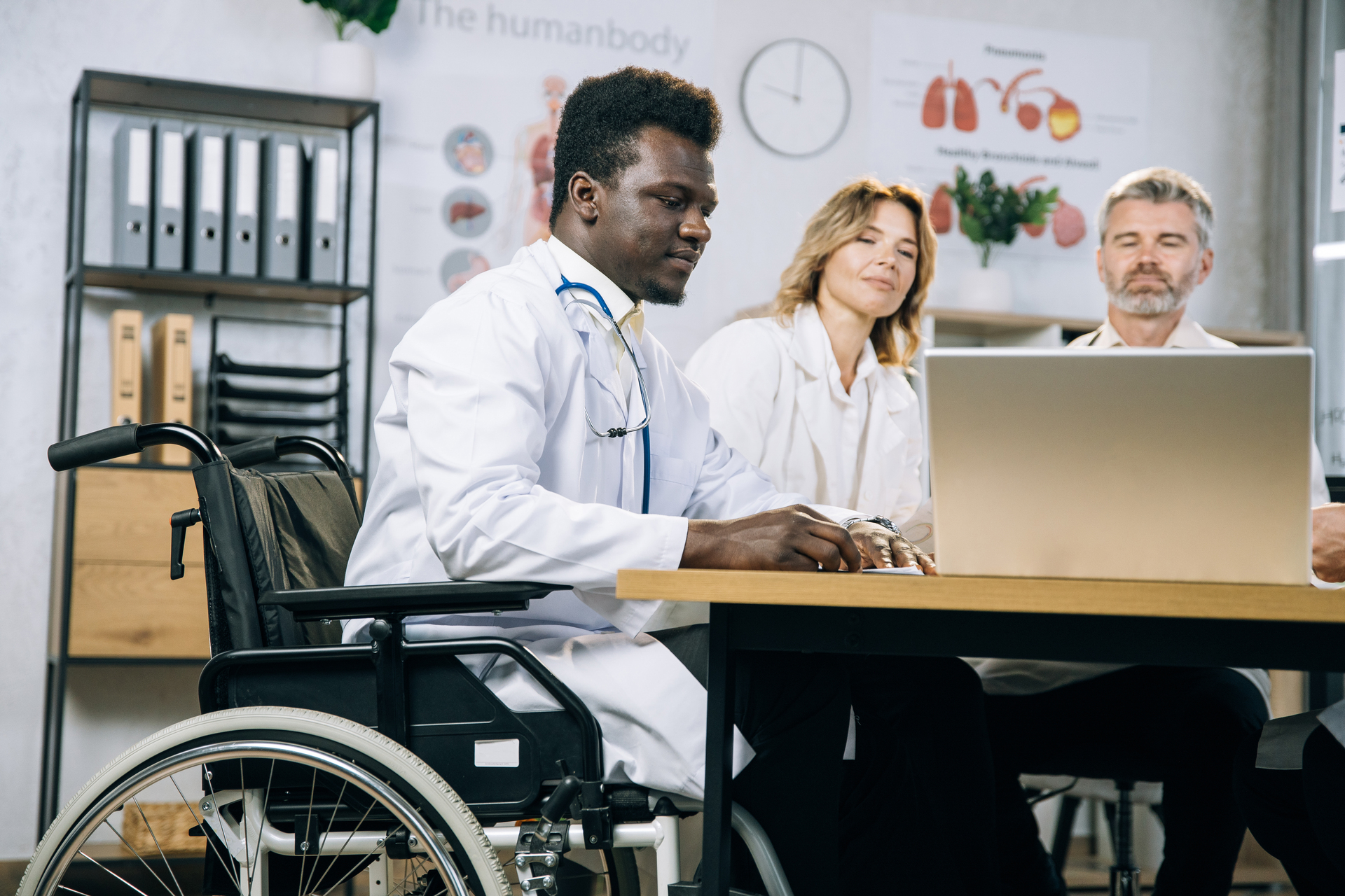 Doctor in wheelchair having meeting with colleagues
