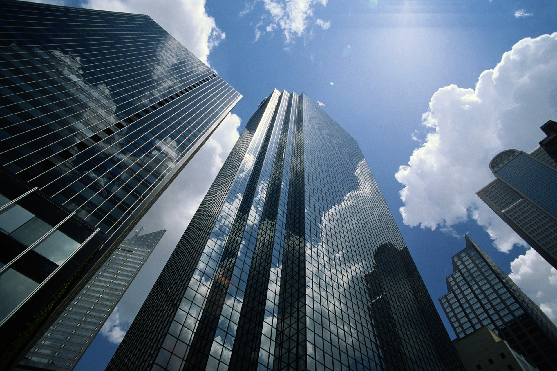 Office buildings reflecting clouds, low angle view