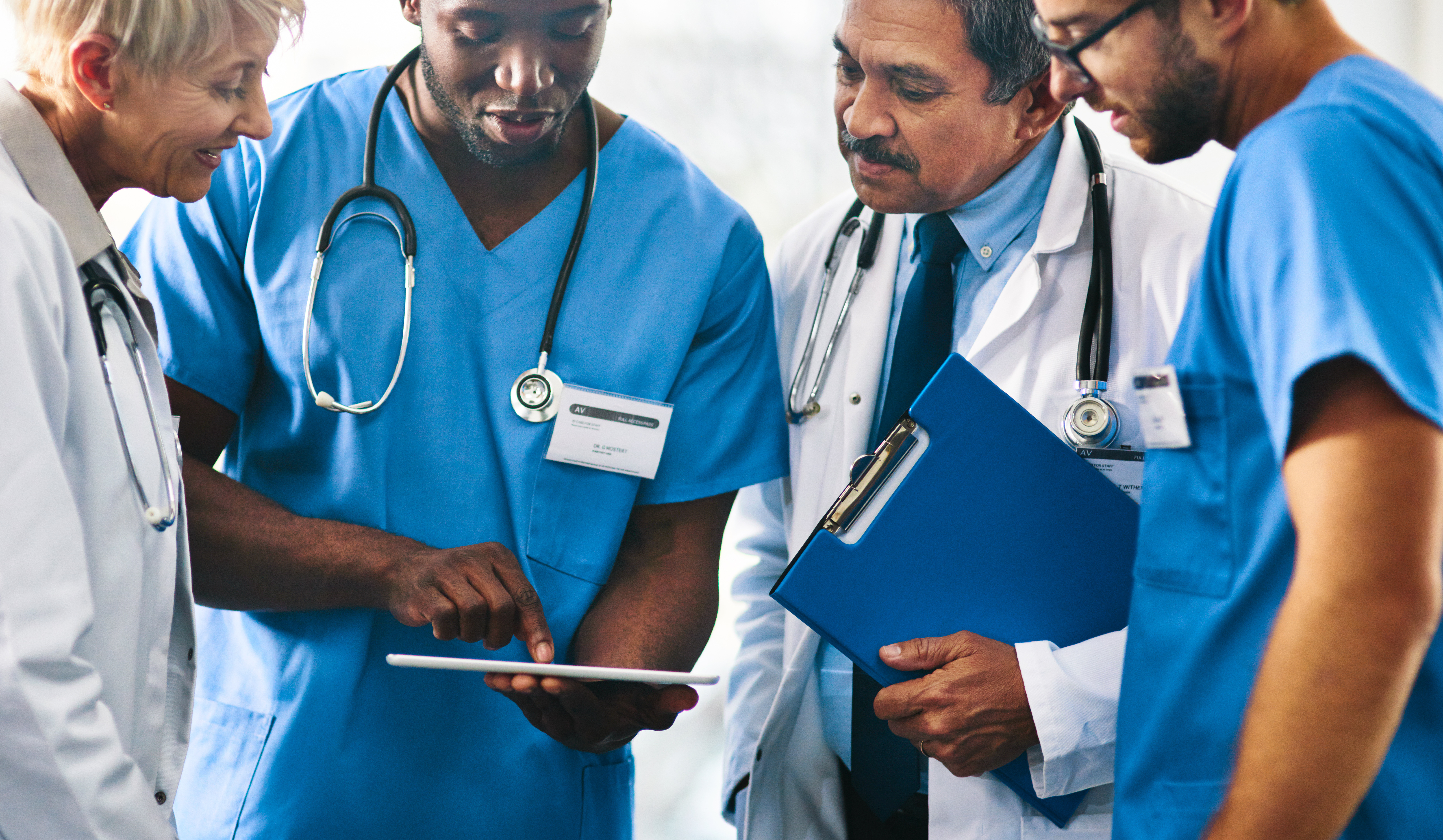 Health care professionals reviewing information on a tablet