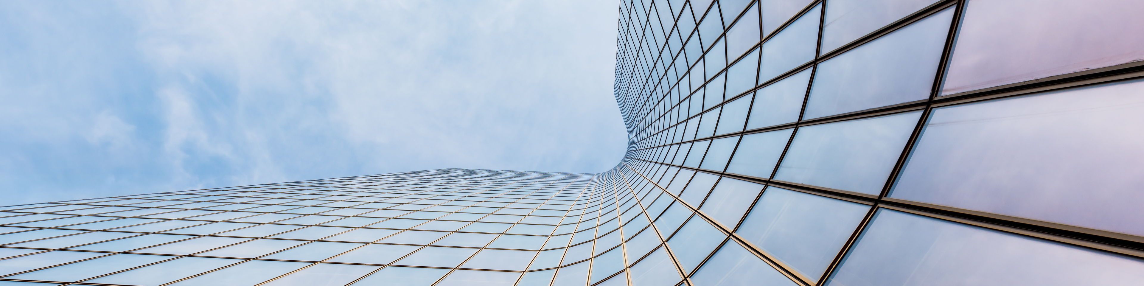 Curved skyscraper against blue sky