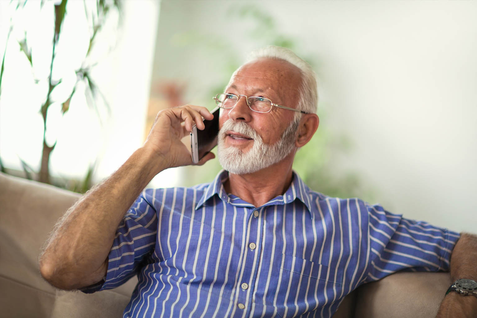 male on couch talking on phone