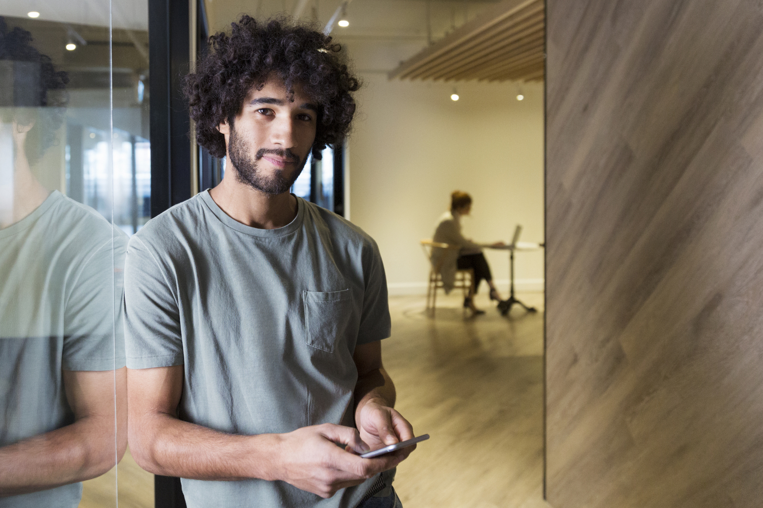 Creative businessman using cell phone in modern office