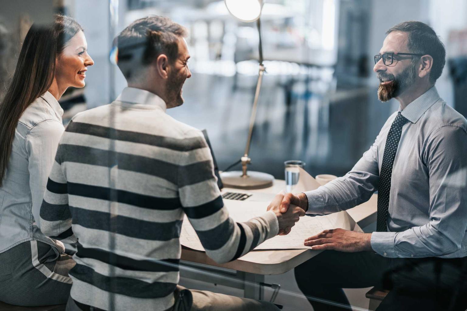 Mature man shakes couples hands