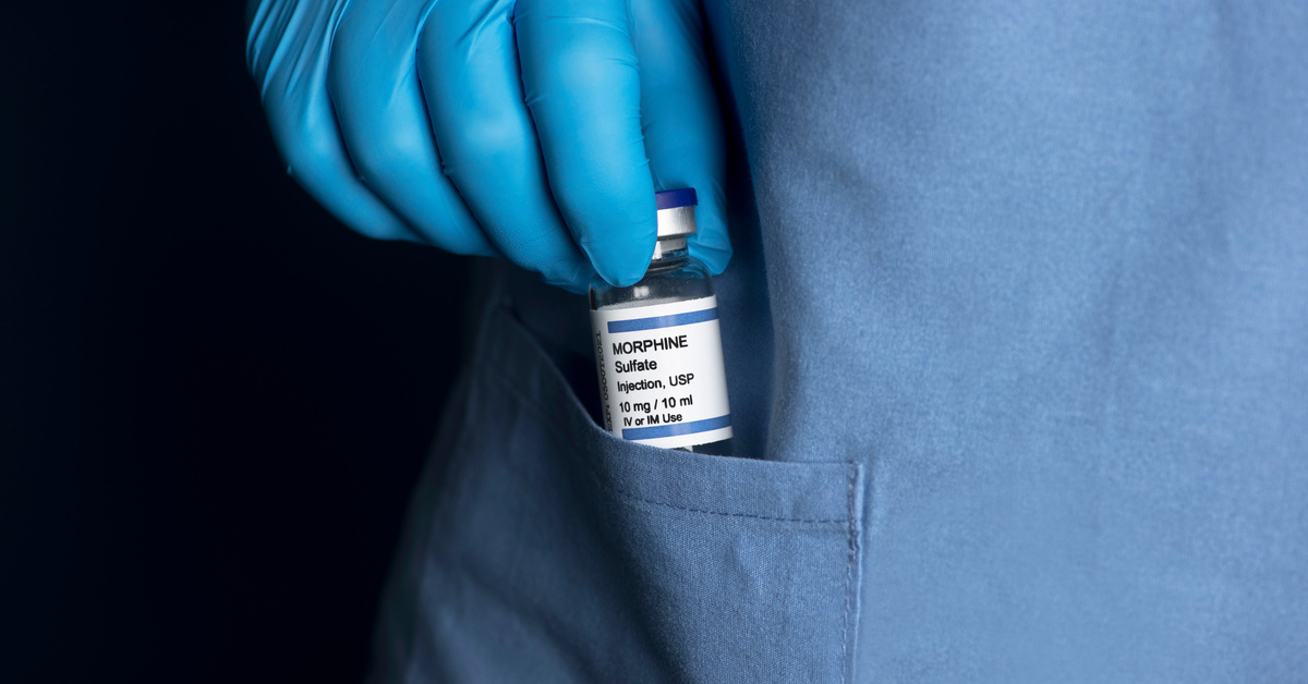 Healthcare professional pocketing a morphine bottle