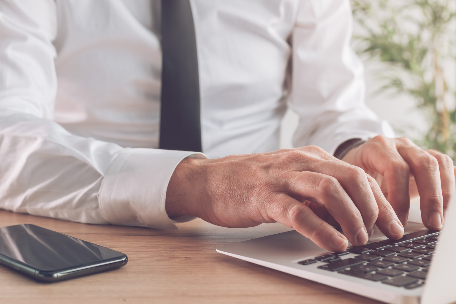 Closeup of man hands typing on laptop in office