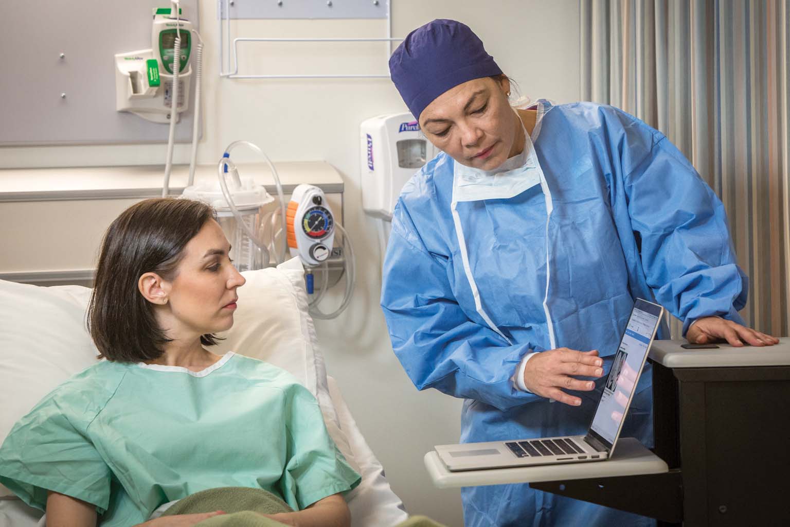 surgeon showing patient UpToDate on laptop