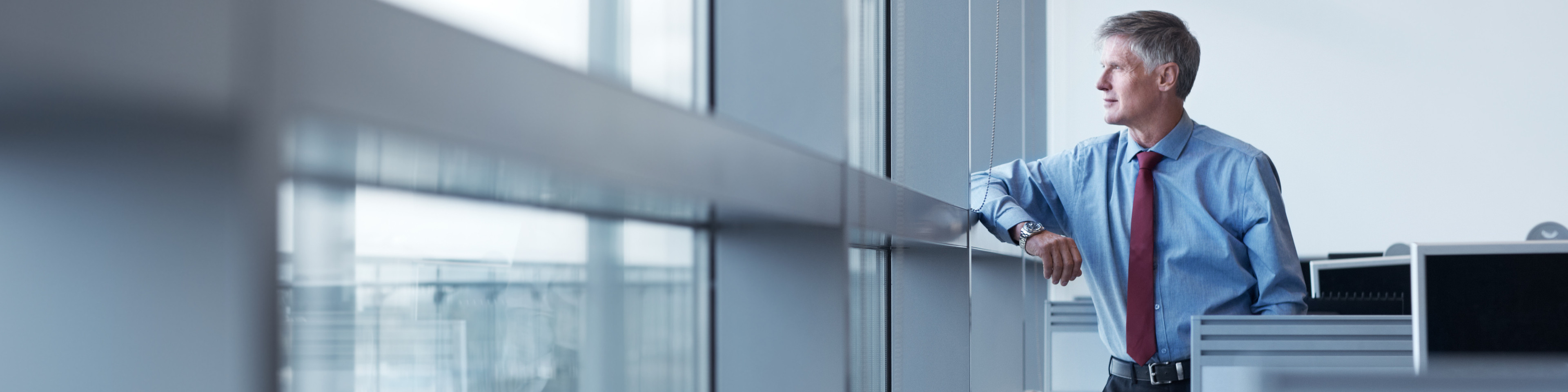 Shot of a mature businessman looking out the window of his office