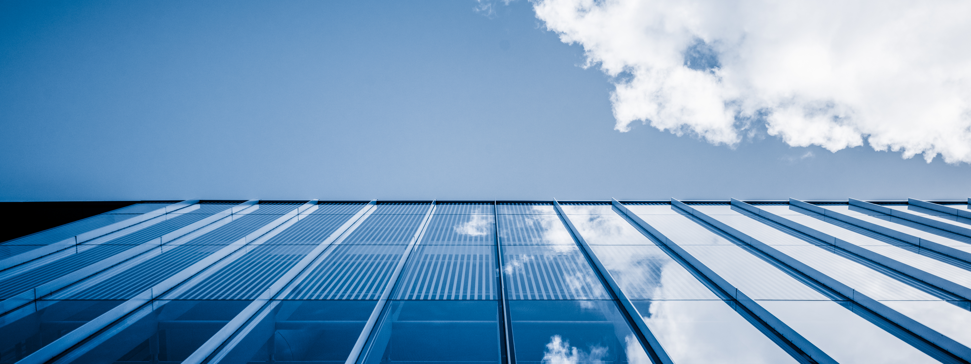 Clouds reflected in windows of modern office building,