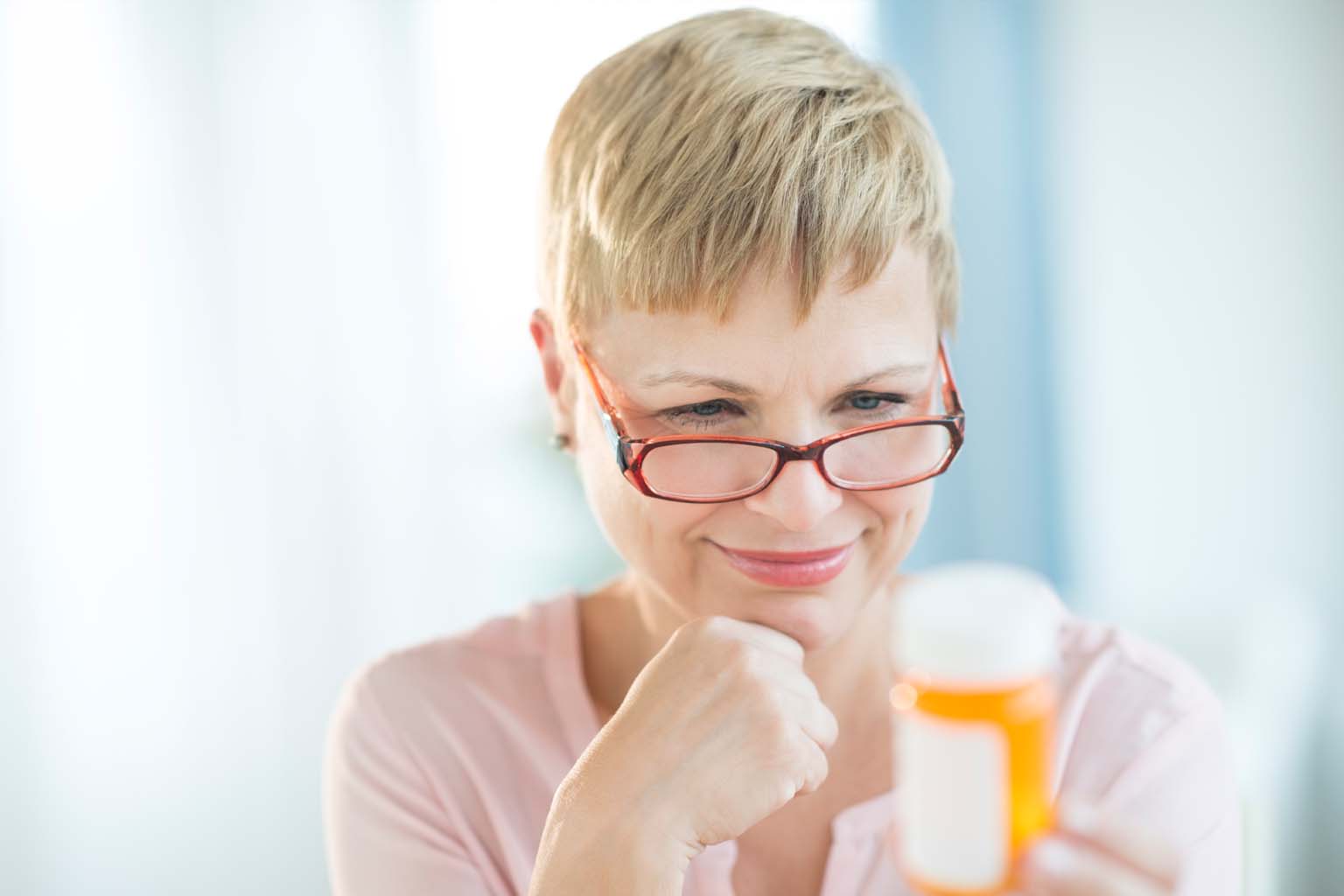 woman reading label on prescription bottle