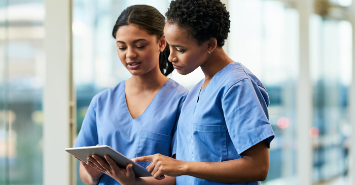 Two nurses consult information on tablet