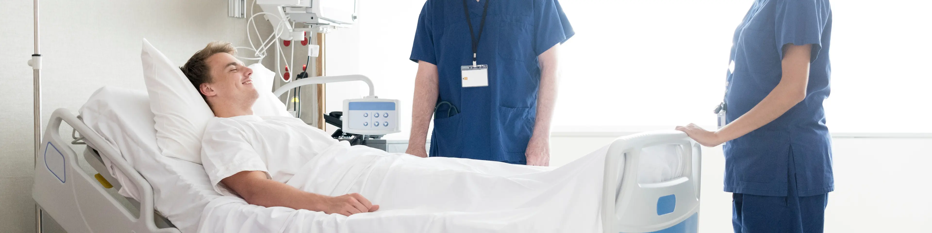 Patient laying in hospital bed next to nurse